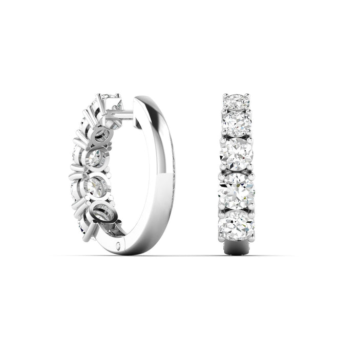 14K white gold huggie earrings with graduated round lab-grown diamonds by Paul Nudelman Jewellers.