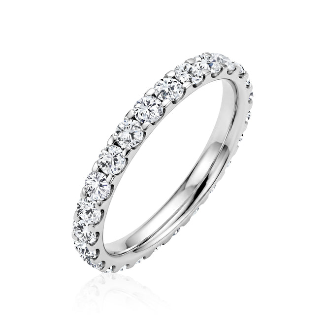 A 14 karat white gold eternity ring set with lab-grown round diamonds. The full eternity design features diamonds set continuously around the band, offering consistent brilliance from every angle. A versatile piece that works as a wedding band or a standalone statement ring.