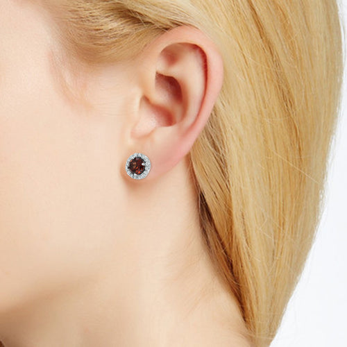 Garnet and diamond halo stud earring on ear