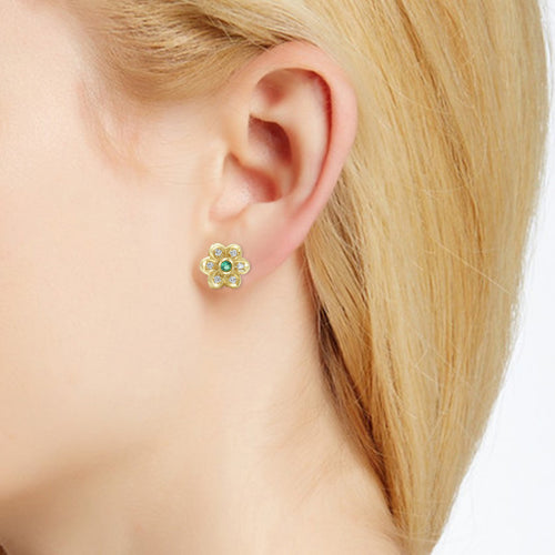 Diamond and emerald flower earring on ear